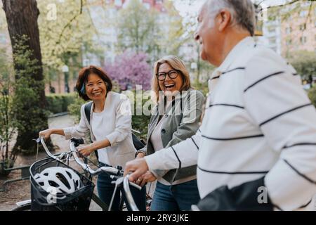 Glückliche Seniorenfreunde mit Fahrrädern im Park Stockfoto