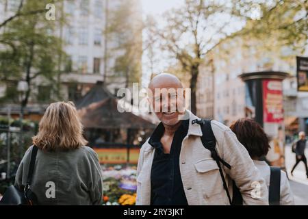 Porträt eines lächelnden älteren Mannes mit rasiertem Kopf auf der Straße Stockfoto