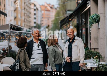 Glückliche männliche und weibliche Freunde, die sich auf der Straße amüsieren Stockfoto