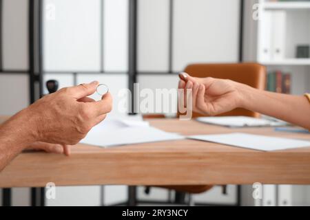 Reifes Paar mit Eheringen im Büro, Nahaufnahme. Scheidungskonzept Stockfoto