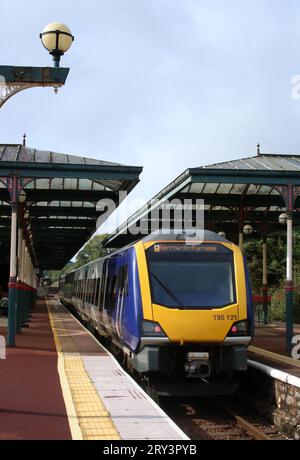 Northern Trains Civity Class 195 Dieseltriebwagen am Bahnsteig im Ulverston Bahnhof am 22. September 2023 mit Schnellzug. Stockfoto