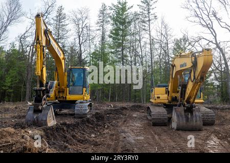 CROW WING CO, MN - 10. MAI 2023: Vorderansicht zweier gut gebrauchter Komatsu-Bagger, die auf einer Baustelle eines zukünftigen neuen Wohngebäudes geparkt sind Stockfoto