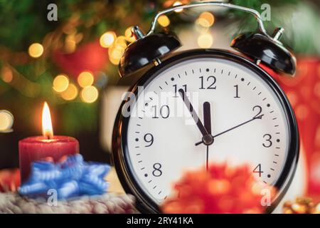 Der Wecker zeigt an, dass es in fünf Minuten zwölf Uhr ist, das neue Jahr. Fünf Minuten bis zwölf, Silvester. Nahaufnahme. Neujahr b Stockfoto