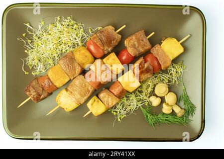 Das Fleisch wird auf Spießen über einem offenen Feuer gekocht. Fleisch und Gemüse auf langen, dünnen Bambus- oder Metallspießen, über einem offenen Feuer oder auf einem Grill Stockfoto