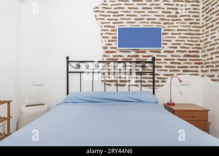 Ein Schlafzimmer mit Doppelbett und schwarzem Kopfteil aus Metall Stockfoto