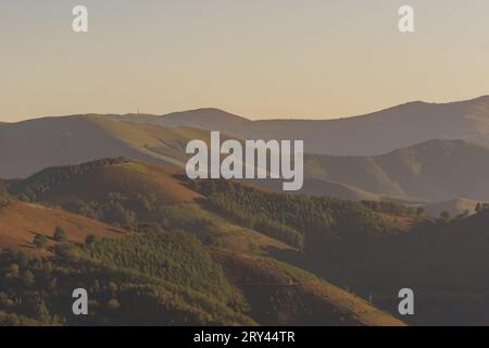 Baskische Landschaft zur goldenen Stunde bei Sonnenuntergang mit wunderschönen Hügeln bedeckt mit Bäumen, Aiako Harria, Gipuzkoa, Baskenland, Spanien Stockfoto