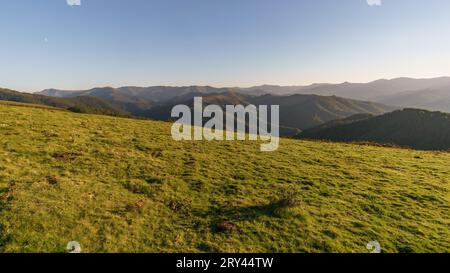 Baskische Landschaft zur goldenen Stunde bei Sonnenuntergang mit wunderschönen Hügeln und Wiesen im Vordergrund, Aiako Harria, Gipuzkoa, Baskenland, Spanien Stockfoto