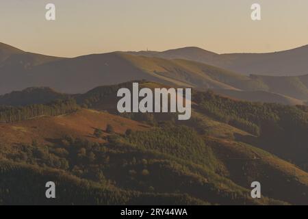 Baskische Landschaft zur goldenen Stunde bei Sonnenuntergang mit wunderschönen Hügeln bedeckt mit Bäumen, Aiako Harria, Gipuzkoa, Baskenland, Spanien Stockfoto