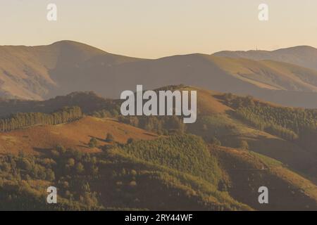 Baskische Landschaft zur goldenen Stunde bei Sonnenuntergang mit wunderschönen Hügeln bedeckt mit Bäumen, Aiako Harria, Gipuzkoa, Baskenland, Spanien Stockfoto