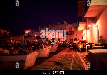 Terrasse eines Restaurants und Fischerboote im alten Fischerhafen von Naoussa bei Nacht, Paros, Kykladen, Griechenland, Restaurant Terrasse und Angeln Stockfoto