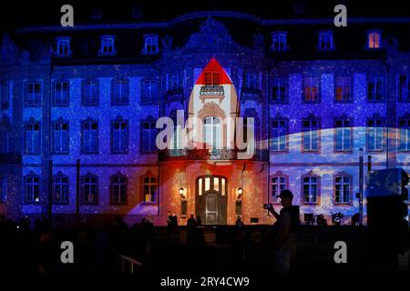 Mainz leuchtet das Late Light Festival, 28.09.2023 Besucher:innen bestaunen den Osteiner Hof am Schillerplatz vom 28. bis zum 30. September 2023 erstrahlt die Mainzer Innenstadt in besonderem Glanz. Von der Rheingoldhalle bis zum Schillerplatz werden mehrere Gebaeude illuminiert und kuenstlerisch in Szene gesetzt. Verschiedene Licht-Installationen und Video-Projektionen sogenannte Mappings lassen prominente Bauwerke wie den Dom St. Martin, das Staatstheater Mainz, den mainz STORE am Markt, das Rathausplateau/die Rheingoldhalle, das Deutsche Bank-Gebaeude im ehem. Karstadt-Areal, den Kirsch Stockfoto