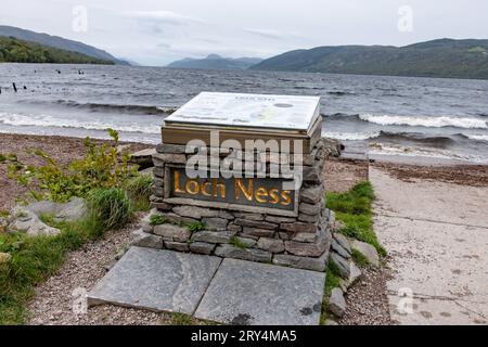 Ein steinernes Podest mit einer Informationstafel vor der Kulisse des Sees - der Strand Dores Beach am Ostufer von Loch Ness in Schottland ist ein beliebter Spot für Wassersportler und Jäger von Nessie, dem Monster von Loch Ness. 28.09.2023 Dores Schottland Großbritannien *** Ein Steinsockel mit einer Informationstafel vor der Kulisse des Loch Dores Beach am Ostufer des Loch Ness in Schottland ist ein beliebter Ort für Wassersportler und Jäger von Nessie, the Loch Ness Monster 28 09 2023 Dores Scotland United Kingdom Credit: Imago/Alamy Live News Stockfoto