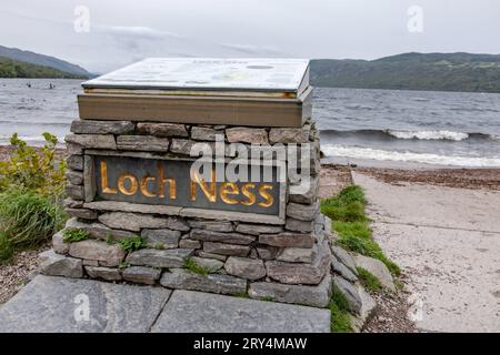 Ein steinernes Podest mit einer Informationstafel vor der Kulisse des Sees - der Strand Dores Beach am Ostufer von Loch Ness in Schottland ist ein beliebter Spot für Wassersportler und Jäger von Nessie, dem Monster von Loch Ness. 28.09.2023 Dores Schottland Großbritannien *** Ein Steinsockel mit einer Informationstafel vor der Kulisse des Loch Dores Beach am Ostufer des Loch Ness in Schottland ist ein beliebter Ort für Wassersportler und Jäger von Nessie, the Loch Ness Monster 28 09 2023 Dores Scotland United Kingdom Credit: Imago/Alamy Live News Stockfoto