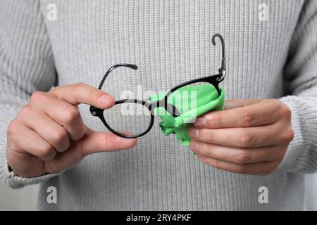 Mann, der die Brille mit Mikrofasertuch abwischt, Nahaufnahme Stockfoto