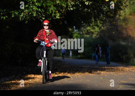 Moskau, Russland. September 2023 28. Eine Frau fährt mit einem Hund Fahrrad und genießt am 28. September 2023 warmes Herbstwetter in einem Park in Moskau, Russland. Quelle: Alexander Zemlianichenko Jr/Xinhua/Alamy Live News Stockfoto