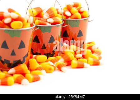 Zinn Kürbis Jack O Laterne Eimer gefüllt mit Candy Corn isoliert auf einem weißen Hintergrund Stockfoto