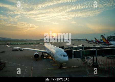 Sonnenaufgang am Incheon International Airport parkten Asiana Airlines Flugzeuge vor den Toren. Morgengrauen am Flughafen. Stockfoto