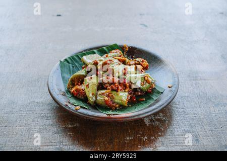 Sambal Terong oder Auberginen-Chili-Sauce auf Tonplatte. Traditionelles indonesisches Gewürzessen. Stockfoto