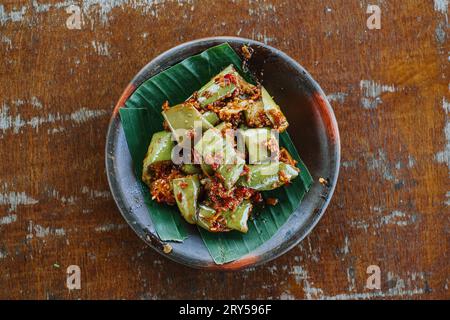 Sambal Terong oder Auberginen-Chili-Sauce auf Tonplatte. Traditionelles indonesisches Gewürzessen. Flach oder Ansicht von oben. Stockfoto