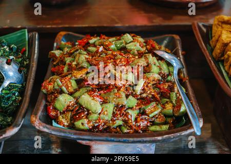 Sambal Terong oder Auberginen-Chili-Sauce auf Tonplatte. Traditionelles indonesisches Gewürzessen. Stockfoto