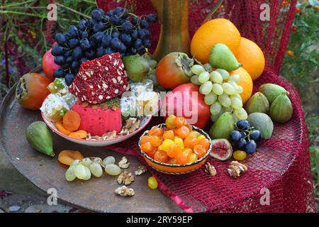 Orientalische Süßigkeiten mit Kupferkrug auf rotem Hintergrund Stockfoto