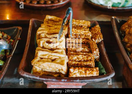 Gebratene tempe und Tahu auf Tonplatte. Traditionelles indonesisches Gewürzessen. Stockfoto