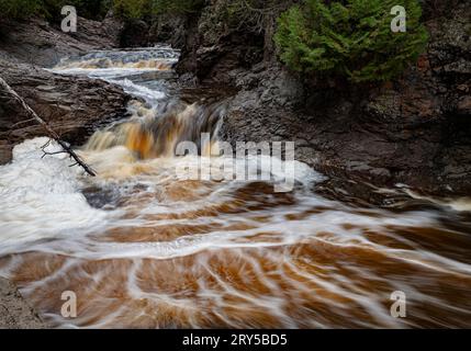 Der Cascade River fließt durch Felsenschluchten und taucht in einen Pool im Canyon, Cascade River State Park, Cook County, Minnesota, ein Stockfoto