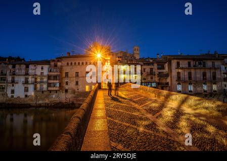 Burg und Kirche von Valderrobres, beleuchtet zur blauen Stunde und in der Nacht, von der Brücke über den Fluss Matarraña (Teruel, Aragon, Spanien) aus gesehen Stockfoto