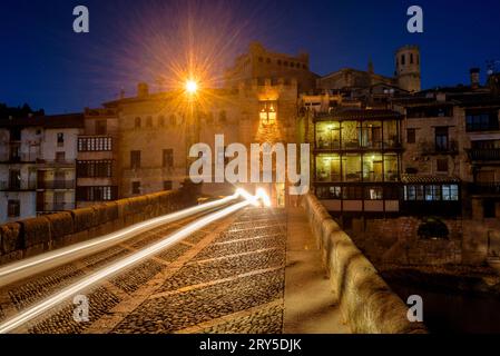 Burg und Kirche von Valderrobres, beleuchtet zur blauen Stunde und in der Nacht, von der Brücke über den Fluss Matarraña (Teruel, Aragon, Spanien) aus gesehen Stockfoto