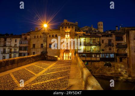 Burg und Kirche von Valderrobres, beleuchtet zur blauen Stunde und in der Nacht, von der Brücke über den Fluss Matarraña (Teruel, Aragon, Spanien) aus gesehen Stockfoto