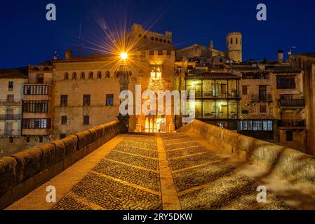 Burg und Kirche von Valderrobres, beleuchtet zur blauen Stunde und in der Nacht, von der Brücke über den Fluss Matarraña (Teruel, Aragon, Spanien) aus gesehen Stockfoto