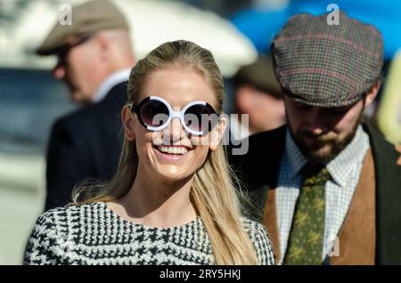 Besucher in historischen Kostümen auf dem Goodwood Revival Motor Circuit. Menschen in Vintage-Kleidung. Frau in Kostüm. Sonnenbrille im 1960er-Jahre-Stil Stockfoto