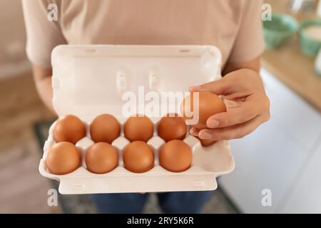 Die Hand zieht ein Ei heraus, um Rührei zu machen Stockfoto