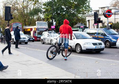 Radfahrer, die die Straße in London überqueren und mehrere Transportarten auf einem Foto 2013 (Fahrrad/Auto/Bus/Minibus/Van/U-Bahn/zu Fuß) Stockfoto