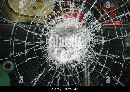 Risse auf dem Glas, Aufprall auf das Glas. Unterbrochenes Fenster Stockfoto