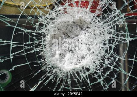 Risse auf dem Glas, Aufprall auf das Glas. Unterbrochenes Fenster Stockfoto