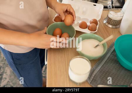 Die Hand zieht ein Ei heraus, um Rührei zu machen Stockfoto