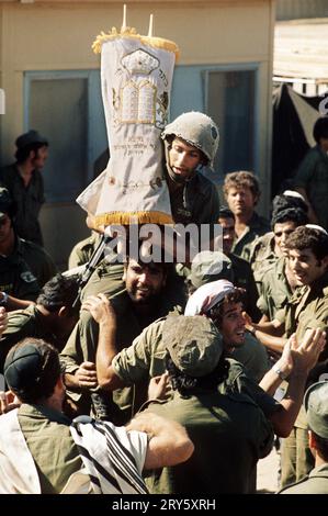 ABGELEGT am 17. Oktober 1973, Israel, ---: Ein israelischer Soldat hält am letzten Tag des Festes der Tabernakel (Sukkot) eine Tora-Rolle an den Fronten der Sinai-Halbinsel. Bis heute hat kaum ein Krieg in Israel so tief in das kollektive Gedächtnis eingeprägt wie der, der am 6. Oktober 1973 auf Jom Kippur begann. Am höchsten jüdischen Feiertag drang eine Allianz arabischer staaten unter der Führung Ägyptens und Syriens überraschend in ein unvorbereitetes Land ein. Mehr als 2600 israelische Soldaten wurden getötet, mehr als 7000 verletzt. Der Schrecken jener Zeit und die Frage, ob der 19-tägige Krieg hätte verhindert werden können Stockfoto