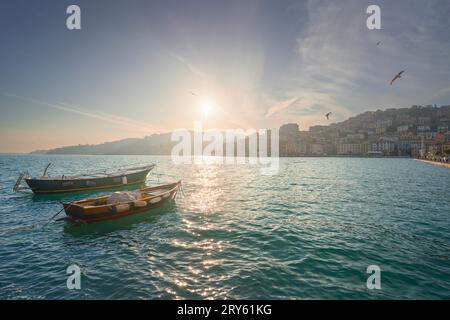 Kleine Holzboote in Porto Santo Stefano am Meer bei Sonnenaufgang und Möwen im Flug. Italienisches Reiseziel. Monte Argentario, Region Toskana, IT Stockfoto
