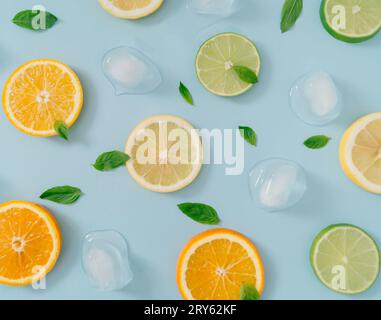 Kreative Komposition im Sommer mit Orangen-, Zitronen- und Limettenscheiben, grünen Minzblättern und Eiswürfeln. Minimales Top-Down-Limonade-Getränk-Konzept. Stockfoto