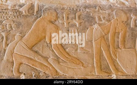 Ägypten, Sakkara, Grab von Mehu, Eingang zwischen den ersten beiden Räumen, Getreide mahlen, um Brot zu machen. Stockfoto