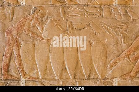 Ägypten, Sakkara, Grab von Mehu, Eingang zwischen den ersten beiden Räumen, Bier in die Gläser gießen. Stockfoto