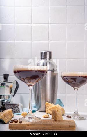 Parmesan Cheese Espresso Martini Cocktail, käsiges Schlagsahne Kaffeegetränk in martini Glas mit geriebenem Parmesan Stockfoto