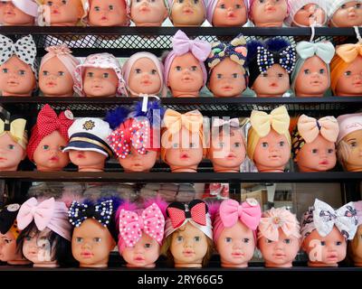 Reihen schrulliger Puppenköpfe mit Haarschleifen zum Verkauf, Istanbul, Türkei Stockfoto