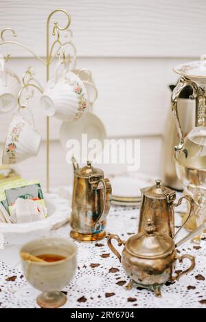 Vintage Teatime mit Keramik, Honig und Silberakzenten Stockfoto