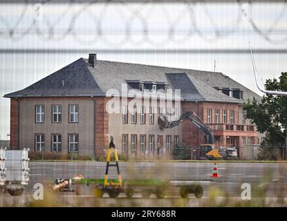 29. September 2023, Brandenburg, Schönefeld: Ein Bagger steht vor dem für den Abbruch vorgesehenen General Hotel auf dem ehemaligen Flugplatz Schönefeld, dem heutigen Flughafen Berlin Brandenburg (BER). Die Vorbereitungen für den Abriss des historischen Generalshotels auf dem Gelände des BER-Flughafens werden trotz starker Proteste von Politikern, Architekten und Denkmalschützern fortgesetzt. Nach Angaben der Bundesbehörde soll der Abriss Anfang 2024 abgeschlossen sein. Foto: Patrick Pleul/dpa Stockfoto