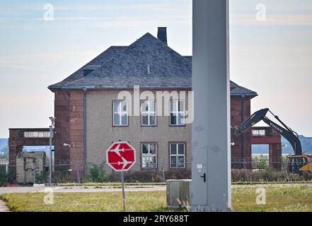 29. September 2023, Brandenburg, Schönefeld: Ein Bagger steht vor dem für den Abbruch vorgesehenen General Hotel auf dem ehemaligen Flugplatz Schönefeld, dem heutigen Flughafen Berlin Brandenburg (BER). Trotz starker Proteste von Politikern, Architekten und Denkmalschützern werden die Vorbereitungen für den Abriss des historischen General Hotels auf dem Gelände des BER-Flughafens fortgesetzt. Nach Angaben der Bundesbehörde soll der Abriss Anfang 2024 abgeschlossen sein. Foto: Patrick Pleul/dpa Stockfoto