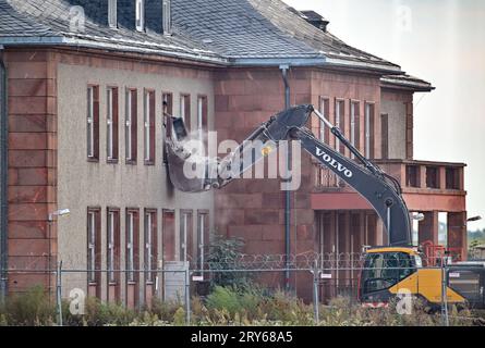 29. September 2023, Brandenburg, Schönefeld: Ein Bagger steht vor dem für den Abbruch vorgesehenen General Hotel auf dem ehemaligen Flugplatz Schönefeld, dem heutigen Flughafen Berlin Brandenburg (BER). Die Vorbereitungen für den Abriss des historischen Generalshotels auf dem Gelände des BER-Flughafens werden trotz starker Proteste von Politikern, Architekten und Denkmalschützern fortgesetzt. Nach Angaben der Bundesbehörde soll der Abriss Anfang 2024 abgeschlossen sein. Foto: Patrick Pleul/dpa Stockfoto