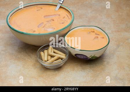 Blick von oben auf eine Kristallschale gefüllt mit gerösteten Vollkornbreadsticks, begleitet von zwei Schüsseln Gazpacho. Mediterrane Küche. Stockfoto