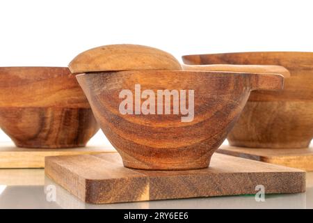 Set aus drei Untersetzern aus Kiefernholz, Tassen aus Holz und Löffeln aus Holz, Makro, isoliert auf weißem Hintergrund. Stockfoto